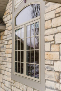 a newly installed window on exterior of home with stone siding
